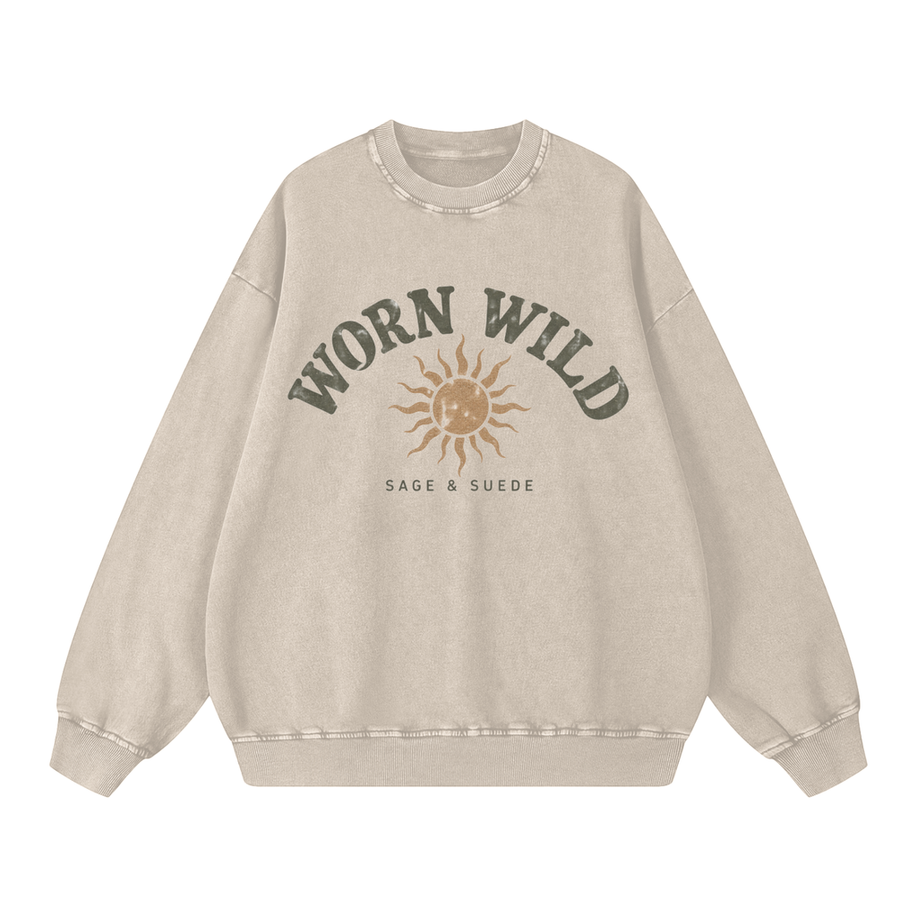 A beige crewneck sweatshirt with a distressed graphic on the front that reads 'WORN WILD' in dark greenish-gray above a tan sun illustration and 'SAGE & SUEDE' underneath, shown on a plain white background.