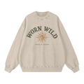 A beige crewneck sweatshirt with a distressed graphic on the front that reads 'WORN WILD' in dark greenish-gray above a tan sun illustration and 'SAGE & SUEDE' underneath, shown on a plain white background.